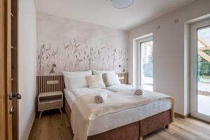 a bedroom with a large bed with white sheets at HelloHal Házak in Tiszafüred +50 photos