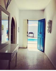 an open door to a room with a table and a mirror at Villa Jasmin in Midoun