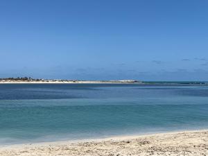 a beach with blue water and a sandy shore at Villa Jasmin in Midoun +3 photos