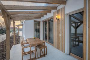a patio with a wooden table and chairs at HelloHal Házak in Tiszafüred