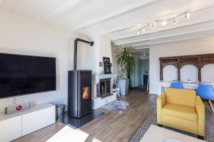 ein Wohnzimmer mit Kamin und einem gelben Stuhl in der Unterkunft le19ème Vuissens in Vuissens + 6 Fotos