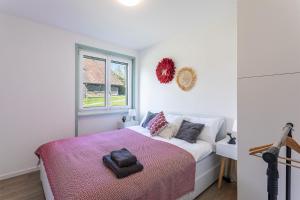 ein Schlafzimmer mit einem Bett mit einer rosa Decke in der Unterkunft le19ème Vuissens in Vuissens