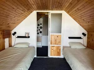 zwei Betten in einem Zimmer mit Holzdecke in der Unterkunft Tiny house palma in Šiljakovina + 14 Fotos