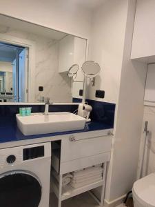 a bathroom with a sink and a mirror at Family Apartment with Sea View 2 Bedrooms & Balcony in Batumi