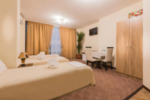 una habitación de hotel con dos camas y una mesa en Hotel-Restaurant DIMAX, en Yoakim-Gruevo