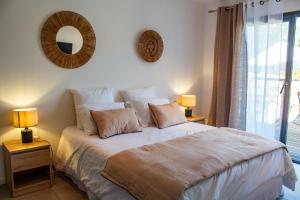 une chambre avec un lit avec deux lampes et une fenêtre dans l'établissement Casa Cavu di Santa Lucia, à Sainte-Lucie de Porto-Vecchio