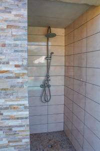 La salle de bains est pourvue d'une douche et d'un mur en briques. dans l'établissement Casa Cavu di Santa Lucia, à Sainte-Lucie de Porto-Vecchio