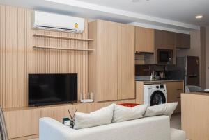 Una sala de estar con un sofá y un televisor de pantalla plana. en The Estates In Walden BTS Asoke, en Bangkok