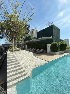 Una piscina con escaleras al lado de un edificio. en The Estates In Walden BTS Asoke, en Bangkok