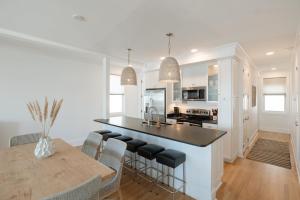 Una cocina y un comedor con mesa y sillas. en Allure by Mira-Mar, en Wrightsville Beach