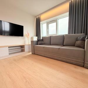 a living room with a couch and a flat screen tv at Apartament GJ PLAZA II in Kielce +13 photos