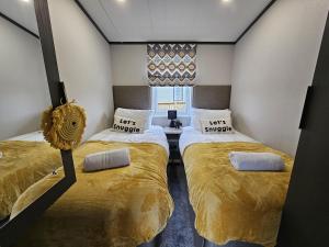 a bedroom with two beds in a room at Bluebird lodge - Brickyard Lakes in Amotherby