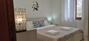 a bedroom with a bed with two towels on it at Luce in Santa Maria Navarrese