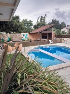 ein Swimmingpool mit Stühlen und ein Haus in der Unterkunft Departamento en la Villa in Villa Carlos Paz