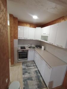 Una cocina con gabinetes blancos y un fregadero. en Vip Bogic 2, en Zlatibor