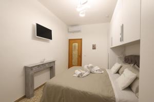 een witte slaapkamer met een bed en een open haard bij Casa Indaterr in Mola di Bari