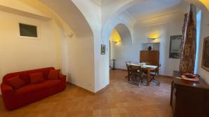 a living room with a red couch and a table at L'Affaccio, 4 in Atrani