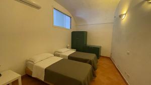 a small room with two beds and a window at L'Affaccio, 4 in Atrani
