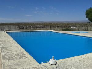 a blue swimming pool in the middle of a field at Terralta Mini Cabañas y Camping in Las Compuertas