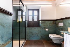 a bathroom with a toilet and a glass shower at El Ladrón De Agua Palacete in Granada