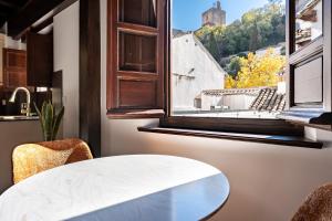 a table and chairs in a kitchen with a window at El Ladrón De Agua Palacete in Granada