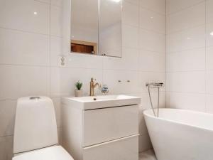 a white bathroom with a sink and a tub and a toilet at Ski lodge Åre by in Åre +13 photos