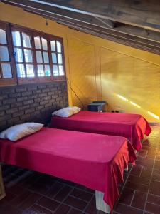 two beds in a room with two windows at NEWEN POSADA in La Consulta