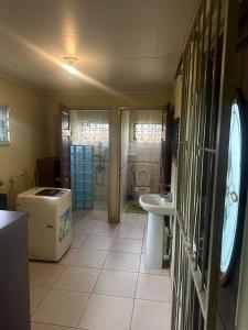 Spacious 4-Bedroom Family Home في باراماريبو: حمام مع حوض ومرحاض