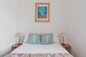 een slaapkamer met een bed met een schilderij aan de muur bij Cozy with Character Vibrant Cottage Style Flat at Leith Links Park in Edinburgh