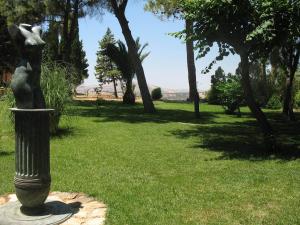 a statue of a woman on a pole in the grass at Case Vacanze Ancora in Porto Empedocle