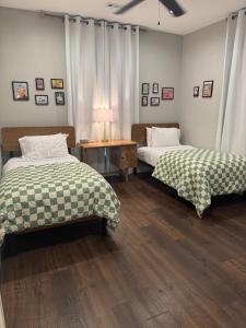 a bedroom with two beds and a table with a lamp at Tulsa Boho Bungalow | King Bed• Near Dtwn•EXPO•TU in Tulsa