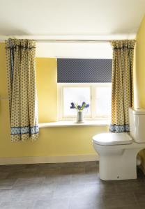 ein Badezimmer mit Toilette und Fenster in der Unterkunft Palace Garden Cottage in Bishop Auckland
