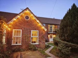 a house with lights on the side of it at Conifer Cottage in North Somercotes