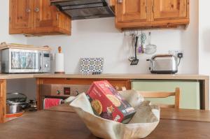 een tafel in een keuken met dozen erop bij Cozy with Character Vibrant Cottage Style Flat at Leith Links Park in Edinburgh +19 foto's