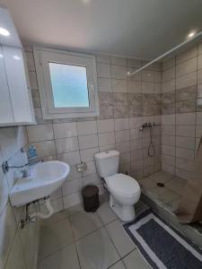 a bathroom with a toilet and a sink at The Garden House in Paradisi in Paradeísion