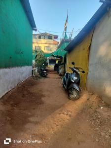 a motorcycle parked in an alley next to a building at Swastik Guest House in Arambol