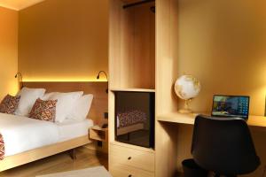 una camera da letto con un letto e una scrivania con un computer di Hotel-Restaurant Stand'Inn a Foetz
