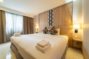 a hotel room with a bed with towels on it at Rodina Beach Hotel in Jomtien Beach