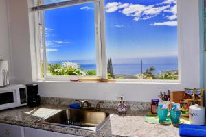 a kitchen counter with a sink and a window at Kailua Kona Overlook Suites in Kailua-Kona