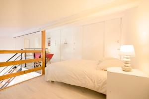 ein weißes Schlafzimmer mit einem Bett und einer Treppe in der Unterkunft Charmant cocon, vue mer, piscine et clim in La Seyne-sur-Mer