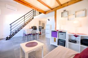 ein Wohnzimmer mit einer Treppe und einem Tisch in der Unterkunft Charmant cocon, vue mer, piscine et clim in La Seyne-sur-Mer