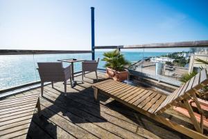 a balcony with a table and chairs and the ocean at LOGIS HOTEL - La Petite Rade in Le Havre