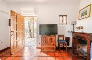 a living room with a television and a fireplace at Casinha da horta in Mirandela