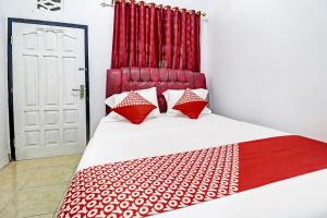 a bedroom with a bed with a red headboard at OYO 91886 Bfs Homestay Syariah in Jambi