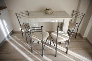 a table with four chairs and a table with a marble table at 4Keys Apartments Nikiti in Nikiti