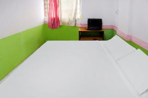a green and white bedroom with a bed and a tv at Hotel O Penginapan Saweri GadingNearKlub Golf Ria Bintan in Nagoya