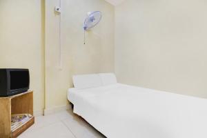 a white room with a bed and a tv at Hotel O Penginapan Saweri GadingNearKlub Golf Ria Bintan in Nagoya