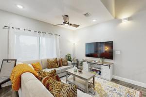 Una sala de estar con un sofá y un televisor. en Gruene Luxury on the Guadalupe, en New Braunfels