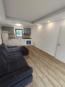 a living room with a black couch and a kitchen at Ostertor in Sarstedt