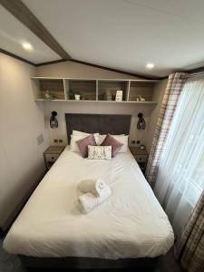 une chambre avec un grand lit avec des serviettes dessus dans l'établissement Grey Goose Lodge with hot tub at Brickyard Lakes, à Amotherby